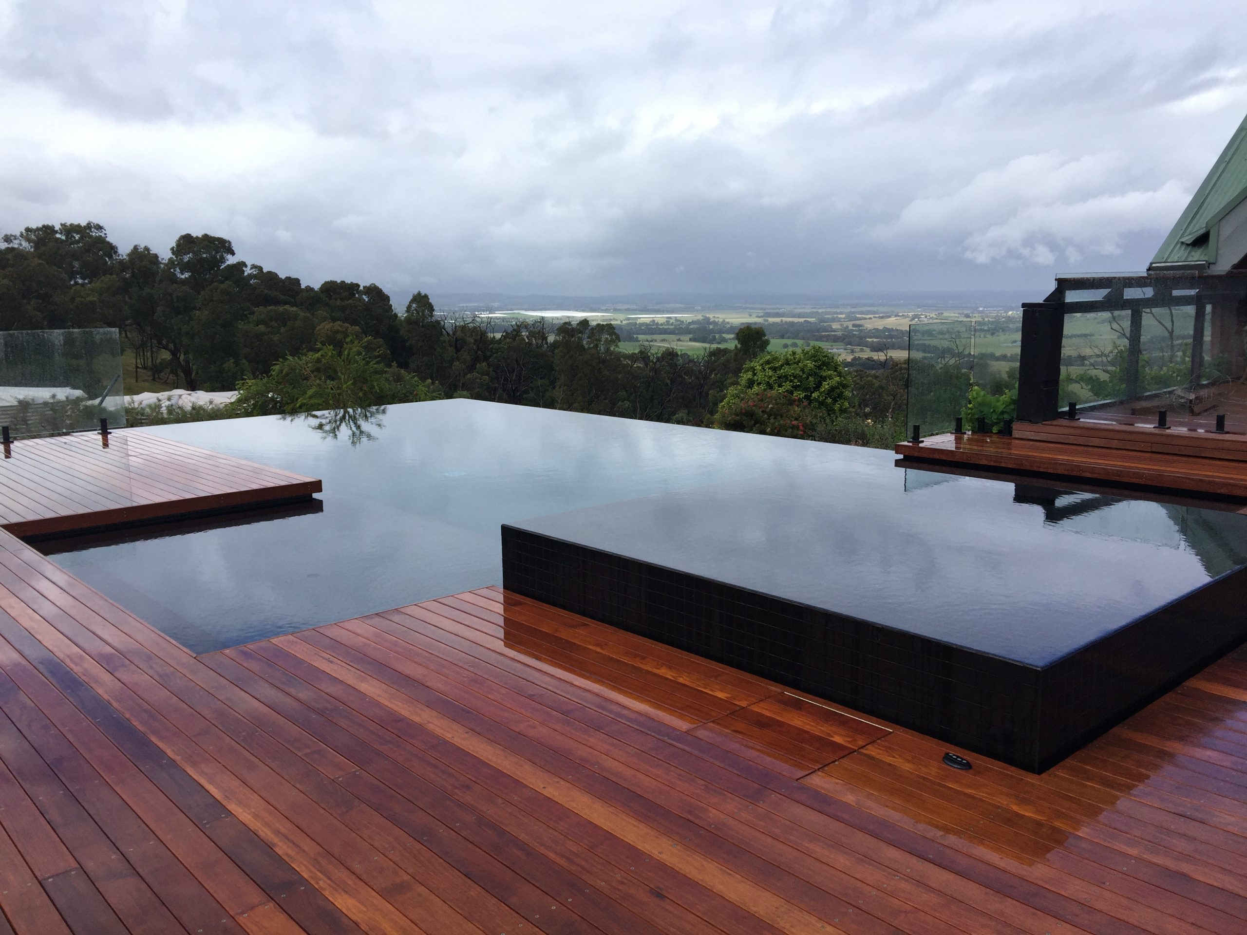 Luxury infinity pool surrounded by a hardwood deck